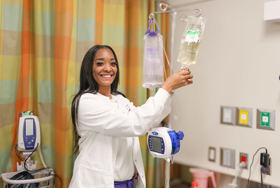 An HCC Coleman College for Health Sciences nursing student smiles for a photo while working.