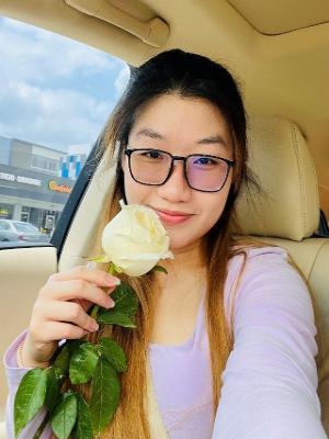 Women holding a white rose in a car
