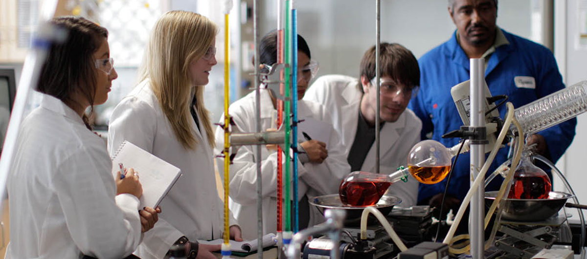 Chemistry students conducting experiments on beakers and test tubes
